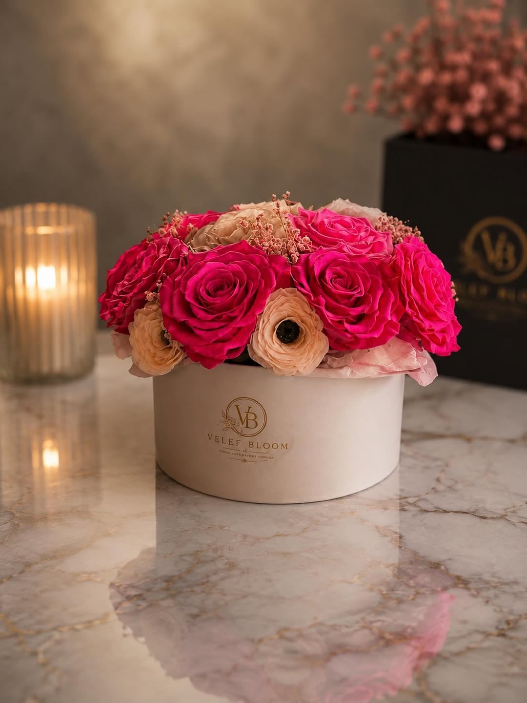 Arreglo Grand de rosas preservadas en fucsia y champaña repartidas en un tazón ancho de cerámica blanca de Velef Bloom, sobre mármol