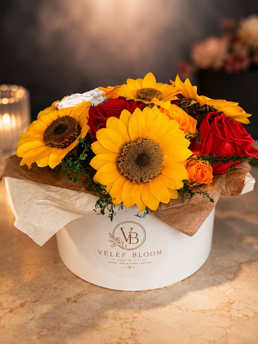 Girasoles preservados con rosas rojas y naranjas en un tazón ancho de cerámica blanca de Velef Bloom